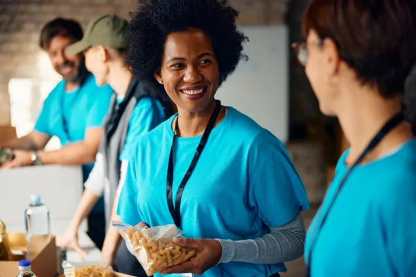 happy-black-volunteer-talking-to-her-coworker-whil-2026-01-07-05-57-38-utc-697b5291297f6